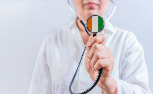 Female doctor holding stethoscope with Ivory Coast flag. National health system of Ivory Coast