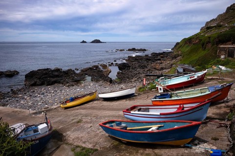 Colourful fishing boats on the sea, Cape Cape Cornwall, behind rock formation, island, The Brisons,