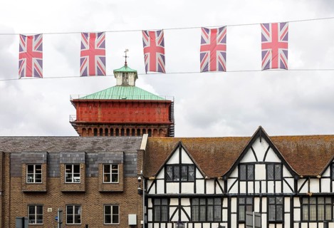 Union Jack bunting flags in a line strung across High Street in town centre of Colchester, Essex,