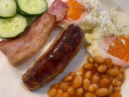 English breakfast on plate with fried eggs, baked beans, bacon, bacon, sausages, greasy, food,