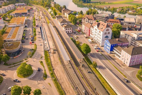 Urban area with rails near a river and green surroundings, electrification of the Hochrheinbahn,