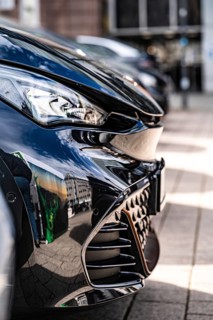 Close-up of shiny front of a black car in an urban environment, Deer, e-carsharing, Stuttgart,