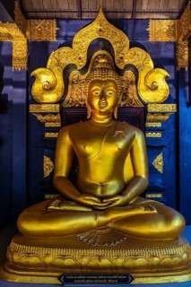 Seated gilded Buddha statue in the Buddhist temple Wat Phra That Don Phra Chan, near Lampang,