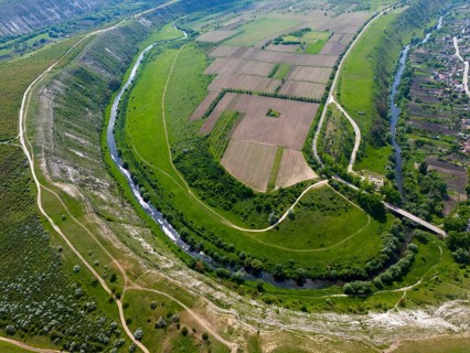 View of a green valley with a winding river and agricultural fields, aerial view, loop of Raut,