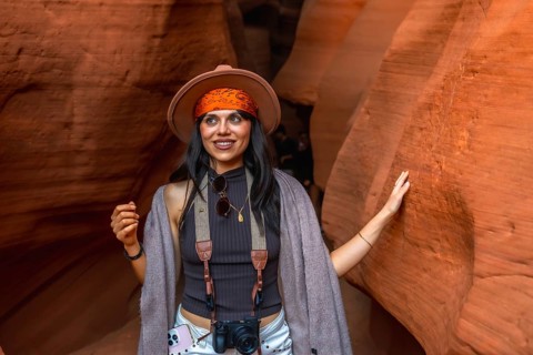 Woman traveler with a camera and hat exploring the beautiful curves and textures of the swirling