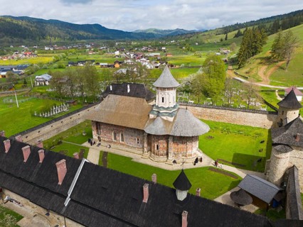 View of a picturesque church within a monastery area surrounded by hills and trees, aerial view,