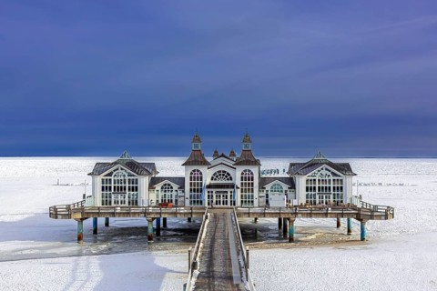Seebrücke Sellin, restaurant on jetty, pier along frozen Baltic Sea on the island Rügen in the snow