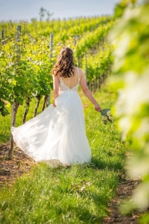 Bride moving along vines holding flower bouquet, wedding, Grossglattbach, Germany