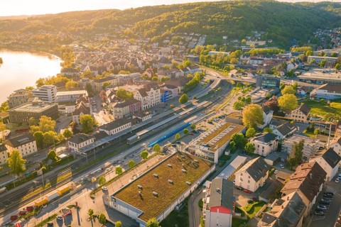 Panorama of a city with a river and mountains in the background under a sunny sky, electrification