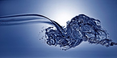 A small longitudinal wave frozen by short exposure in crystal-clear water in the photo studio in