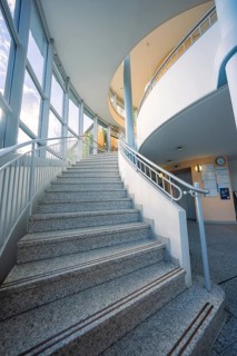 Modern stone staircase in a bright building with large glass windows, old disused hospital, Calw,