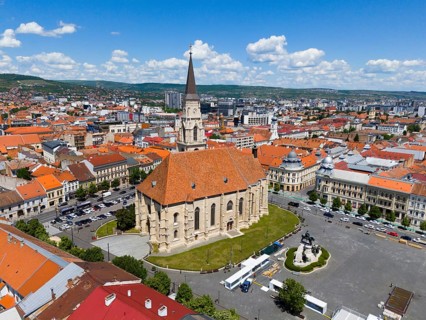 Historic church with red roof in urban landscape under blue sky, aerial view, St. Michael's Church
