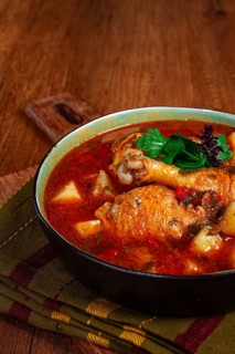 Souzi soup. Georgian dish, meat with oats, tomato sauce and herbs, on a wooden table