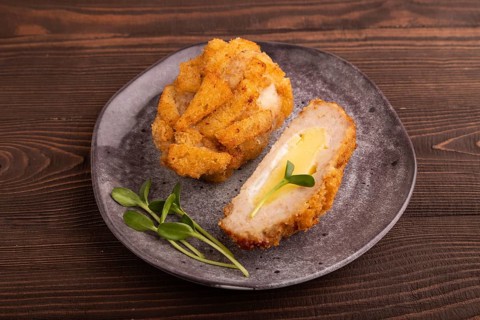 Chicken Schnitzel on gray plate with microgreen on brown wooden background. side view, close up