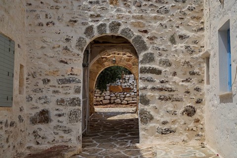 A rustic stone arch in a Mediterranean alley conveys a historic atmosphere, castro, old castle
