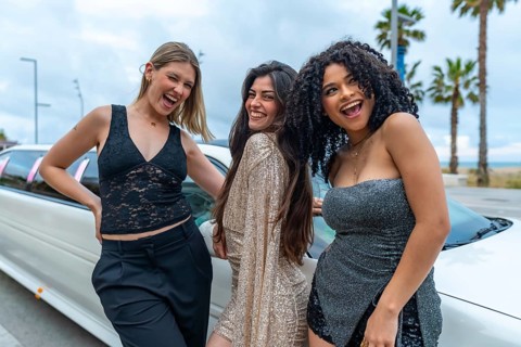 Three young diverse women friends celebrating special event or bachelorette party, smiling and