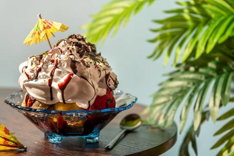 Ice cream with cream, chocolate, crumble and small umbrella