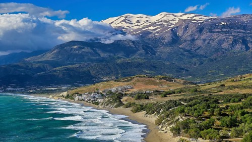 Komos Beach, impressive panoramic view of a beach, sea and snow-capped mountains, Matala, south