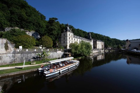 Tour boat and Benedictine Abbey Saint-Pierre de Brantôme on the Dronne River in the morning,