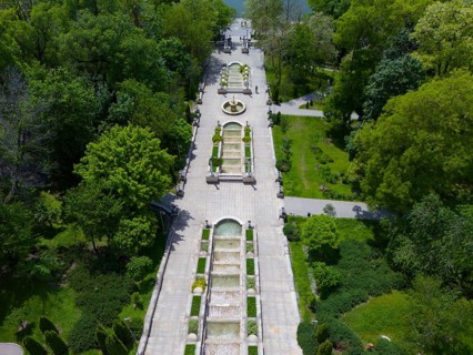 Long symmetrical garden path with fountain nestled in lush nature, cascade staircase, Scara
