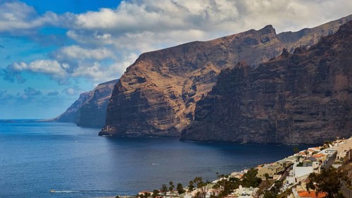 Los Gigantes, sunny coastal landscape with imposing cliffs, calm sea and few clouds, Masca,