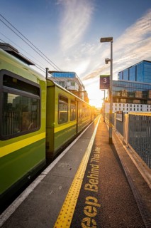 A train on a platform platform at sunset in an urban setting, Docklands, Dublin, Ireland