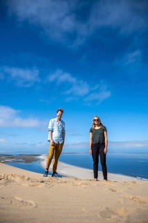 Tourists, young couple drunk on the dunes of the Namib Desert with a view of the Atlantic coast,