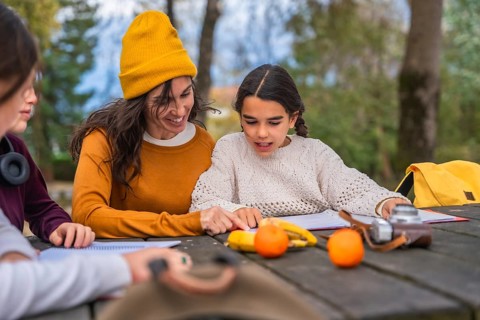 Family enjoying a learning session together, a smiling mother assisting her daughter with