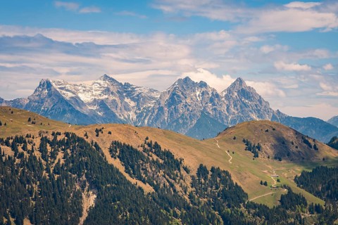 Majestic mountain landscape with snow-capped peaks and green hills, Hahnenkamm, Kitzbühel, Austria