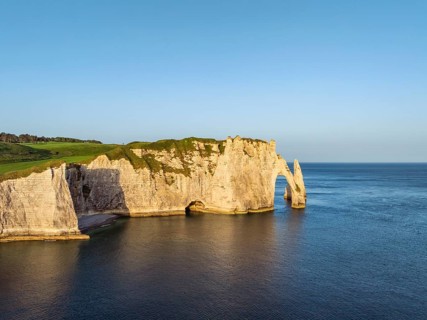 Aerial view of Porte d'Aval rock formation, landmark and natural beauty after sunrise with the