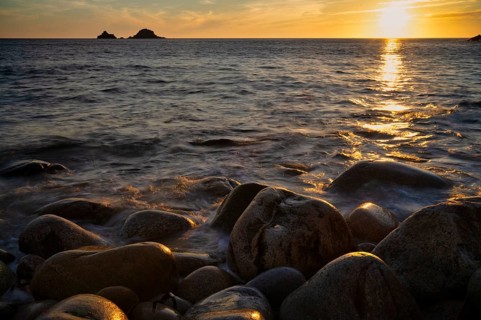 Evening, sunset at sea, in the background rock formation The Brisons, Cot Valley Beach, Porth