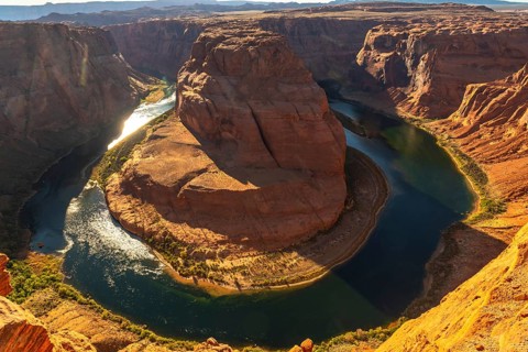 Horseshoe bend showcasing the powerful colorado river making a dramatic u turn around the sandstone