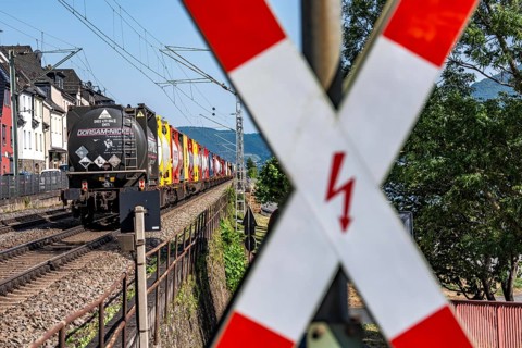 Level crossing, freight train passing through town in Lorchhausen, right next to the residential
