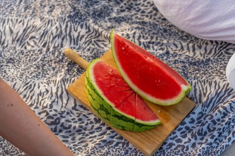 Slices of ripe, red watermelon serving on a wooden cutting board, placed on a patterned leopard