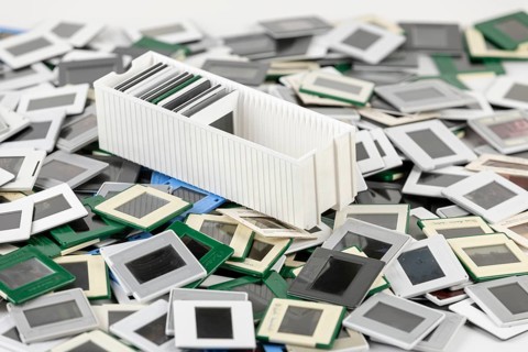 A single slide holder lies in the middle of a chaotic heap of slides