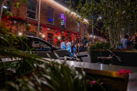 Nighttime street scene with illuminated facades and people enjoying urban nightlife, Nightlife,