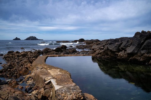 Artificial water basin by the sea, Cape Cape Cornwall, behind rock formation, island, The Brisons,