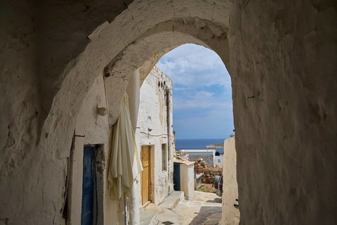 Vaulted passage between white buildings overlooking the sea, main town on Kimolos, Kimolos, Chorio,
