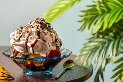 Elaborately decorated ice cream with cream, colorful sprinkles and chocolate