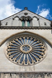 Large, delicately designed rose window in Gothic style on the historic stone façade of the Gothic