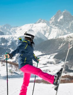 Smiling happy woman skier freerider posing looking at Ushba peak while on snowy slope Tetnuldi