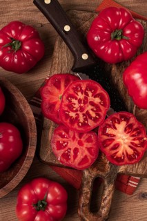 Freshly sliced, pink tomatoes, on a wooden chopping board, with a knife, rustic style, close-up, no