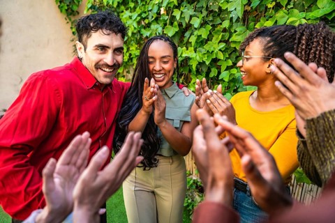 Diverse group of people claps in appreciation and support, celebrating achievements and connections
