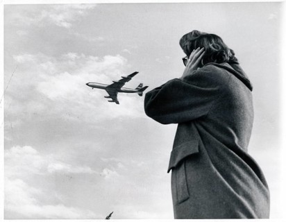 Noise, protection, aircraft noise, person covering their ears while an airplane passes in the sky,