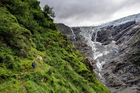 Mountaineers on a hiking trail, cloudy mountain landscape with Grindelwald-Fiescherfirn glacier,