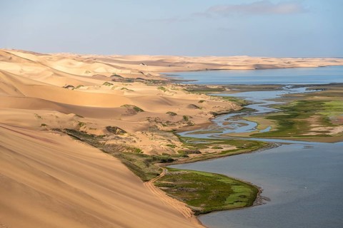 Sand dunes and sea in morning light, Sandwich Harbour Atlantic coast and lagoon, Namib Naukluft