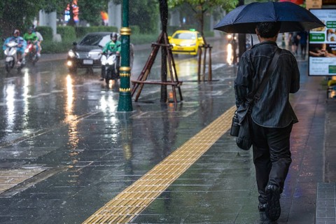 Man with umbrella, Bangkok, Thailand