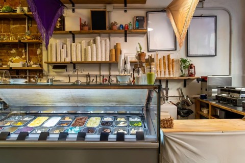 Gelato shop interior with a bright freezer display showcasing colorful artisan ice cream and sorbet