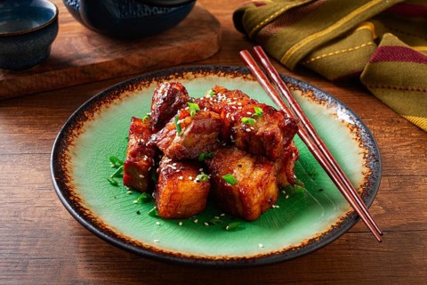 Chinese-style meat with sesame seeds and green onions, on a wooden table, homemade, no people