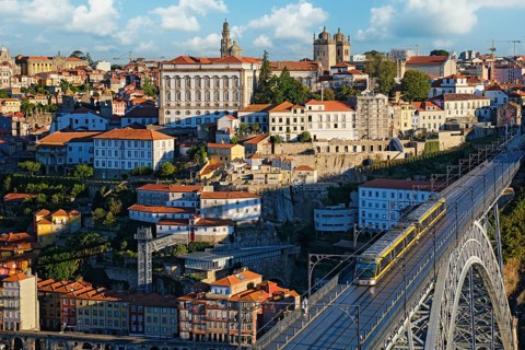 City view of Porto and Ribeira with a tram crossing Dom Luis I Bridge above the Douro River in